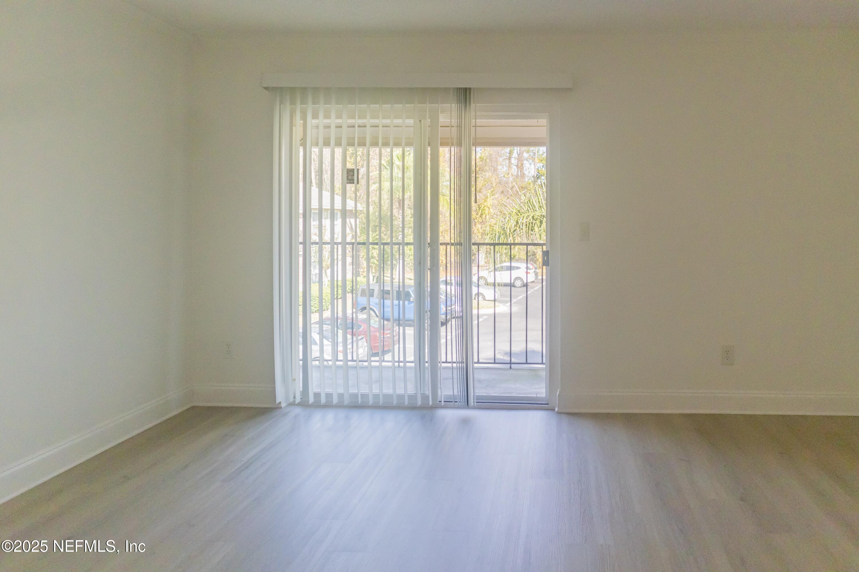 3737 Loretto Road, Unit 114 Jacksonville, FL 32223 - Photo 6 of 11 an empty room with wooden floor and windows