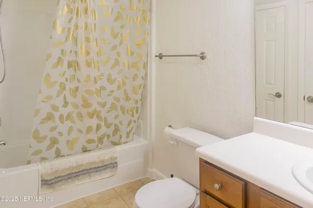 a bathroom with a sink a toilet and shower curtain