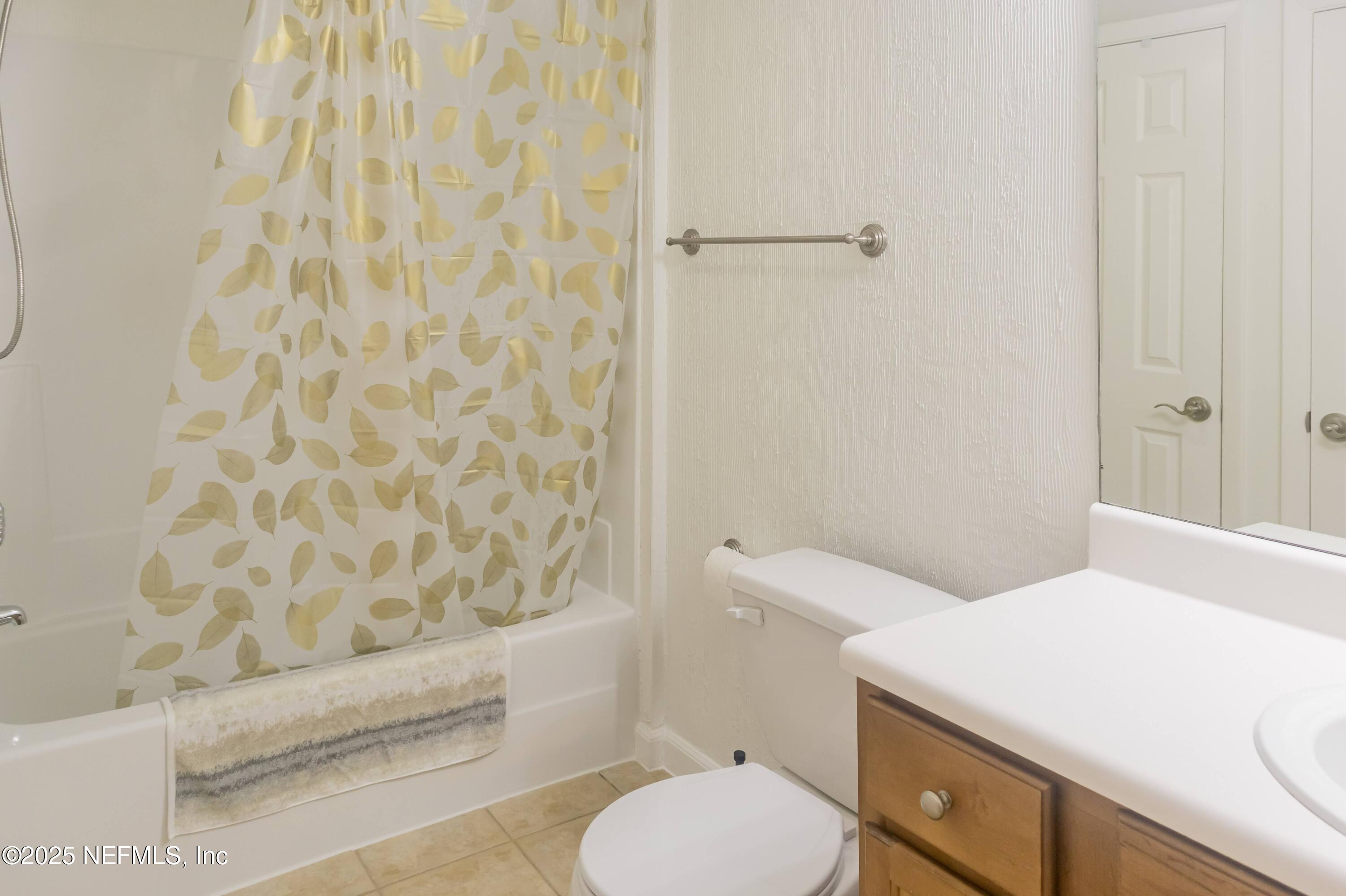 3737 Loretto Road, Unit 114 Jacksonville, FL 32223 - Photo 7 of 11 a bathroom with a sink a toilet and shower curtain