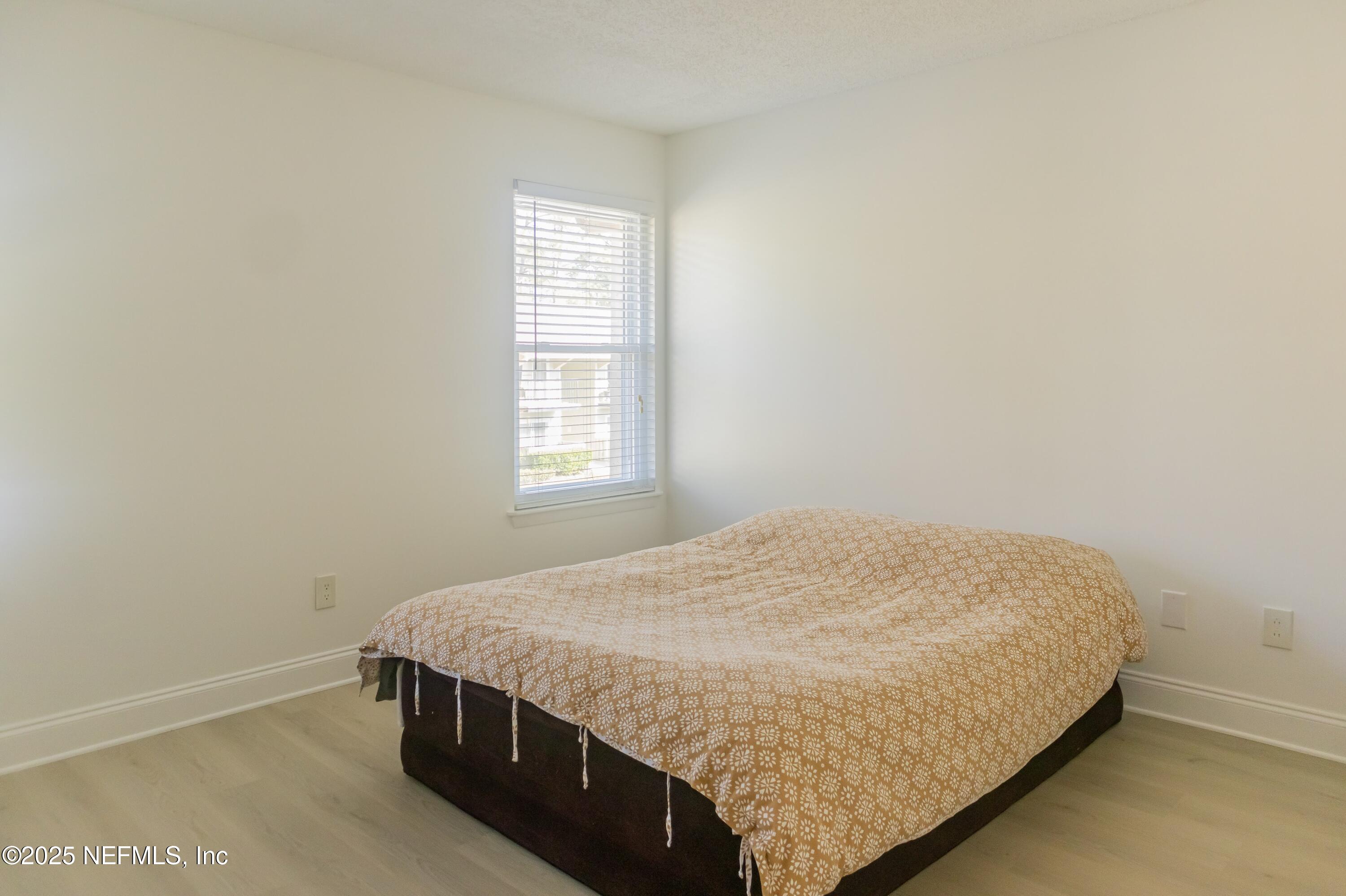 3737 Loretto Road, Unit 114 Jacksonville, FL 32223 - Photo 8 of 11 a bed sitting in a bedroom next to a window