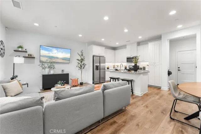 a living room with furniture and a dining table with kitchen view