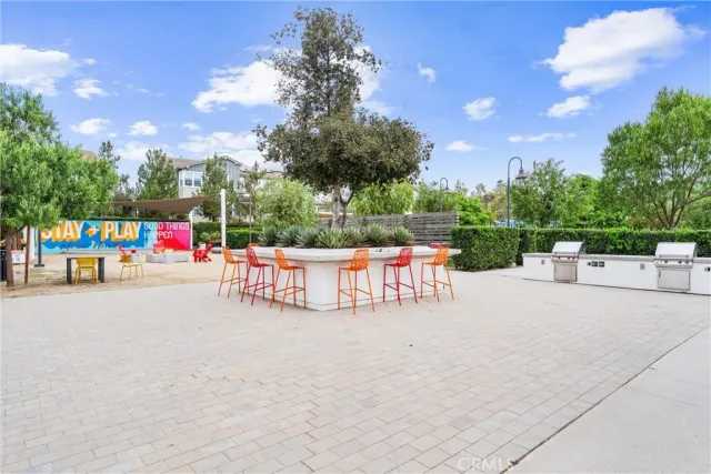 a patio with couches a table and chairs under an umbrella