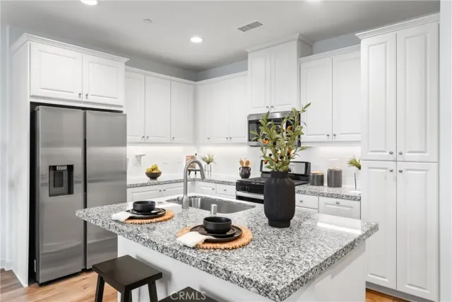a kitchen with stainless steel appliances granite countertop a sink stove and refrigerator