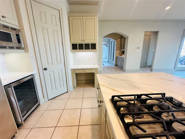 a living room with stainless steel appliances furniture a rug and a kitchen view