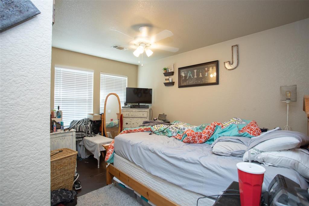 716 Rocky Ridge Flatts Oak Ridge, TX 76240 - Photo 7 of 10 a bedroom with a bed and a chandelier