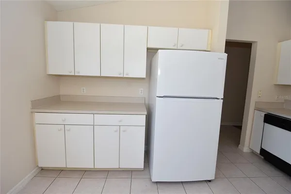 a white refrigerator freezer and a stove sitting inside of a kitchen