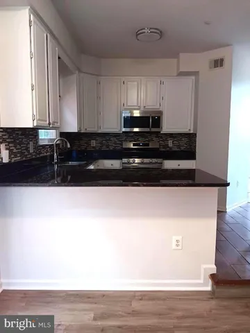 a kitchen with a sink a microwave and cabinets