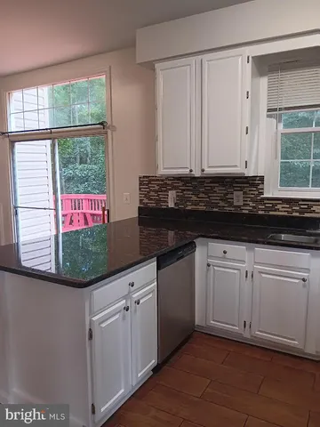a kitchen with granite countertop white cabinets and a window