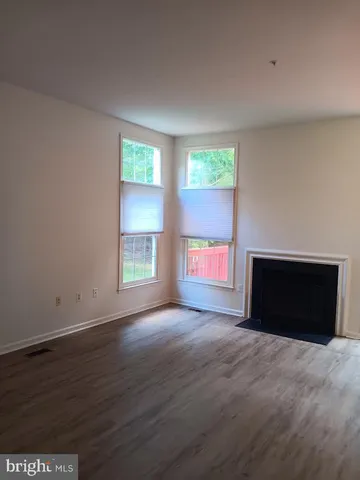an empty room with windows and a fireplace