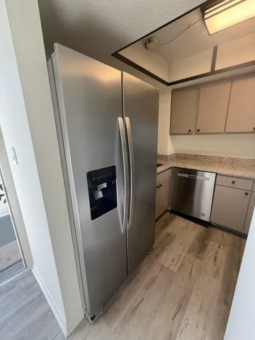 a metallic refrigerator freezer sitting inside of a kitchen