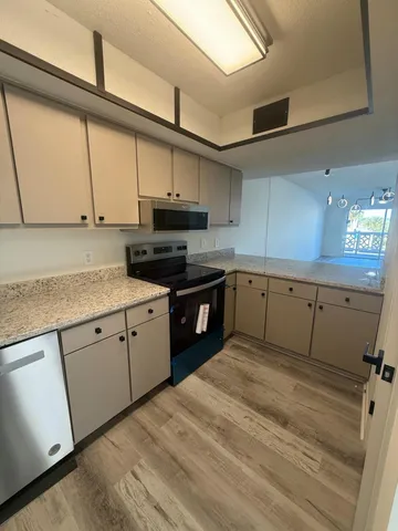 a kitchen with stainless steel appliances granite countertop a sink a stove and cabinets