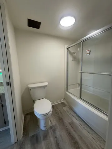 a bathroom with a toilet and a shower