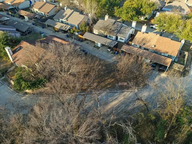 an aerial view of a house with a yard and tree s