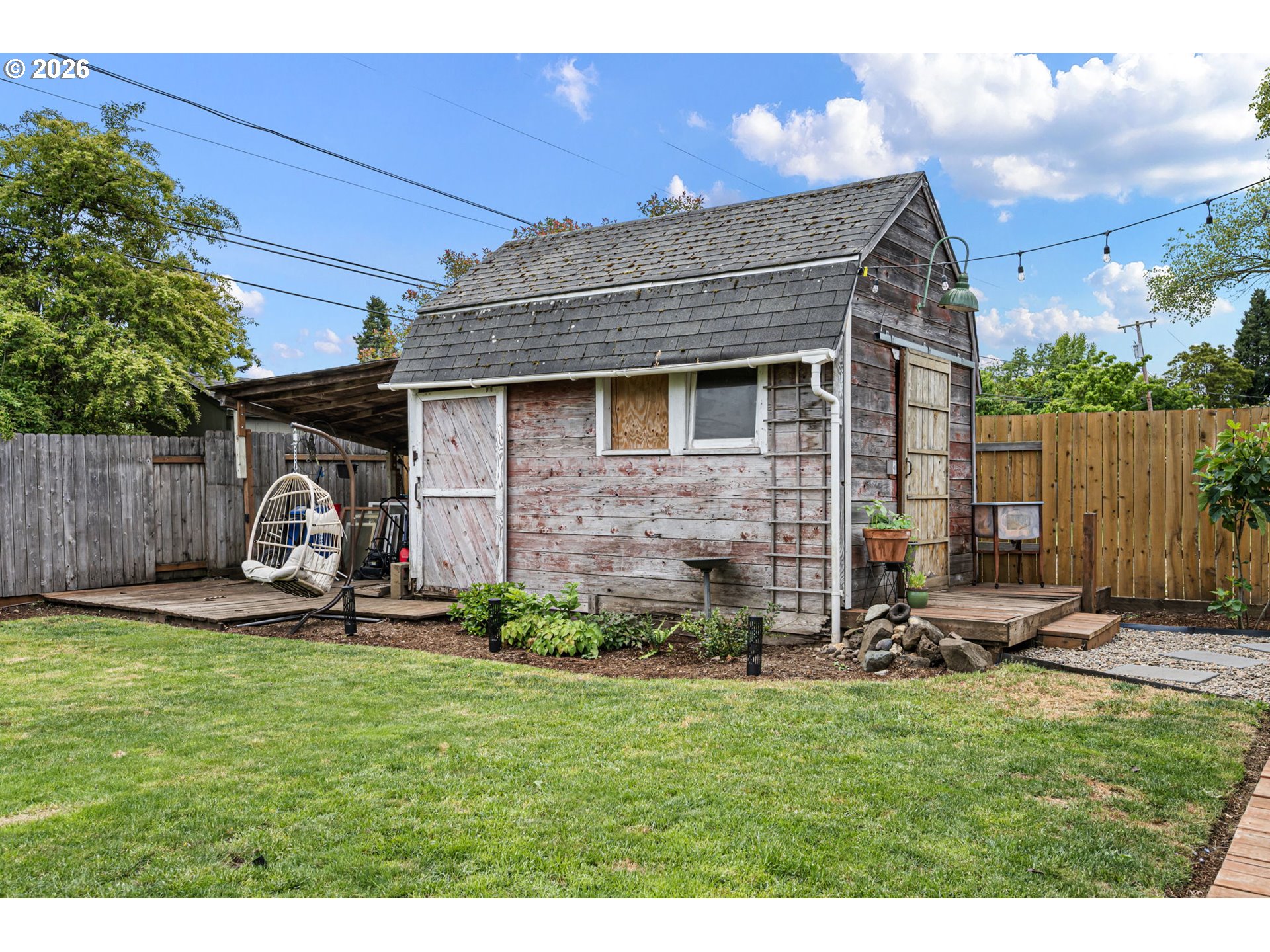 765 Louis Street Eugene, OR 97402 - Photo 40 of 45 a view of a backyard with table and chairs a barbeque and wooden fence