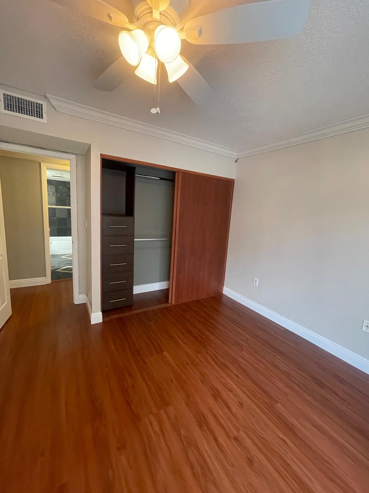 4156 Inverrary Drive, Unit 202 Lauderhill, FL 33319 - Photo 11 of 14 an empty room with wooden floor chandelier fan and windows