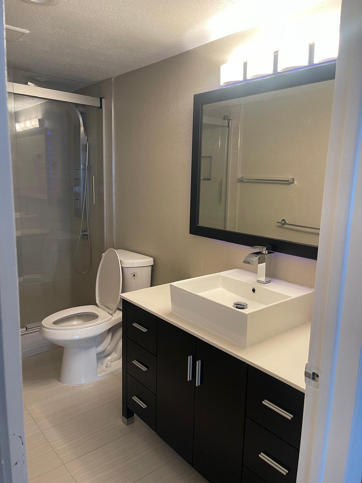 4156 Inverrary Drive, Unit 202 Lauderhill, FL 33319 - Photo 7 of 14 a bathroom with a toilet sink and mirror
