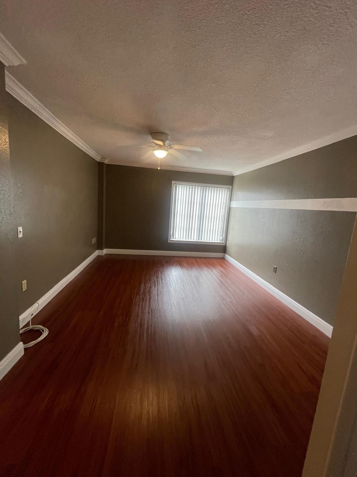 4156 Inverrary Drive, Unit 202 Lauderhill, FL 33319 - Photo 8 of 14 an empty room with wooden floor and windows