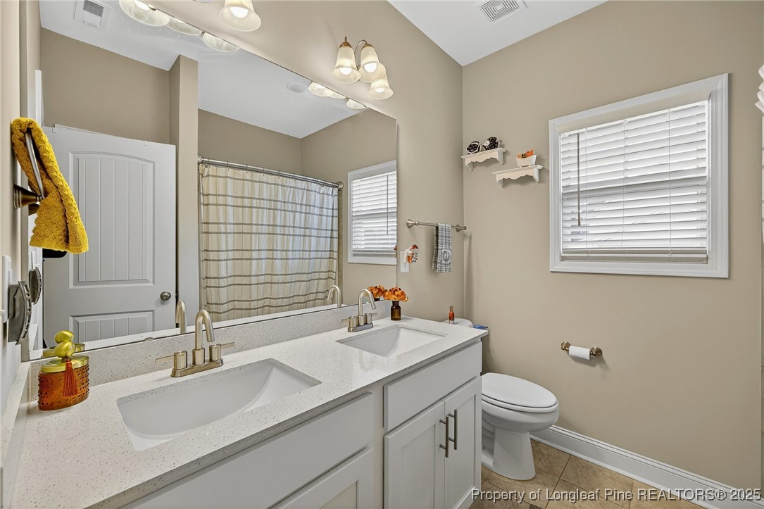 193 Rocking Horse Lane Raeford, NC 28376 - Photo 12 of 25 a bathroom with a sink a toilet and mirror