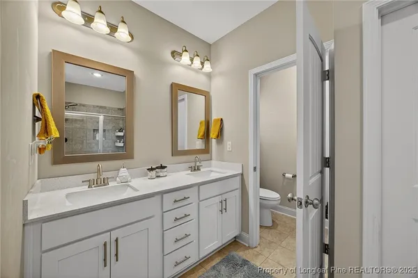 a bathroom with a double vanity sink and a mirror