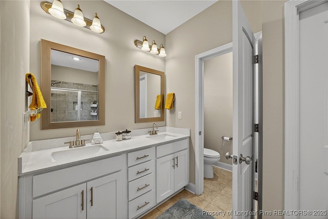 193 Rocking Horse Lane Raeford, NC 28376 - Photo 15 of 25 a bathroom with a double vanity sink and a mirror