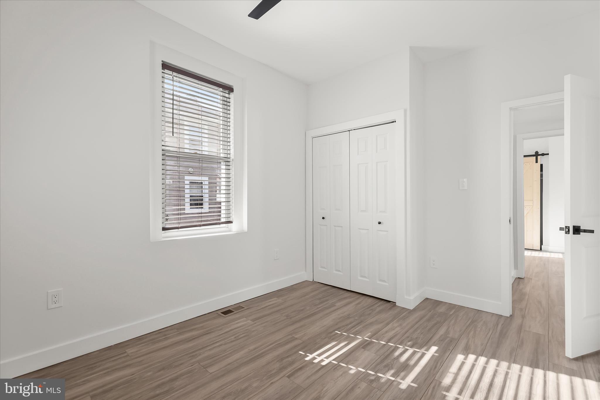 5822 Ethelbert Avenue Baltimore, MD 21215 - Photo 18 of 37 an empty room with wooden floor and windows