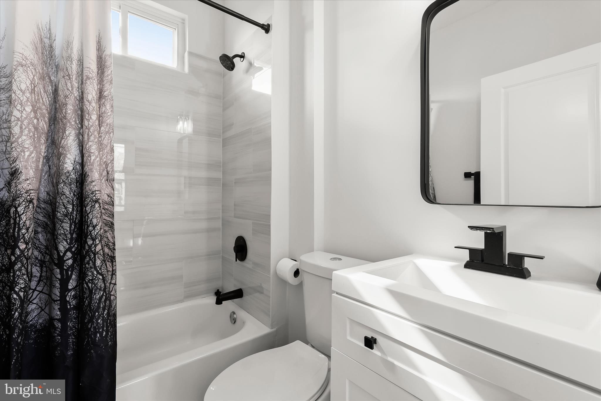 5822 Ethelbert Avenue Baltimore, MD 21215 - Photo 19 of 37 a bathroom with a sink toilet vanity and shower