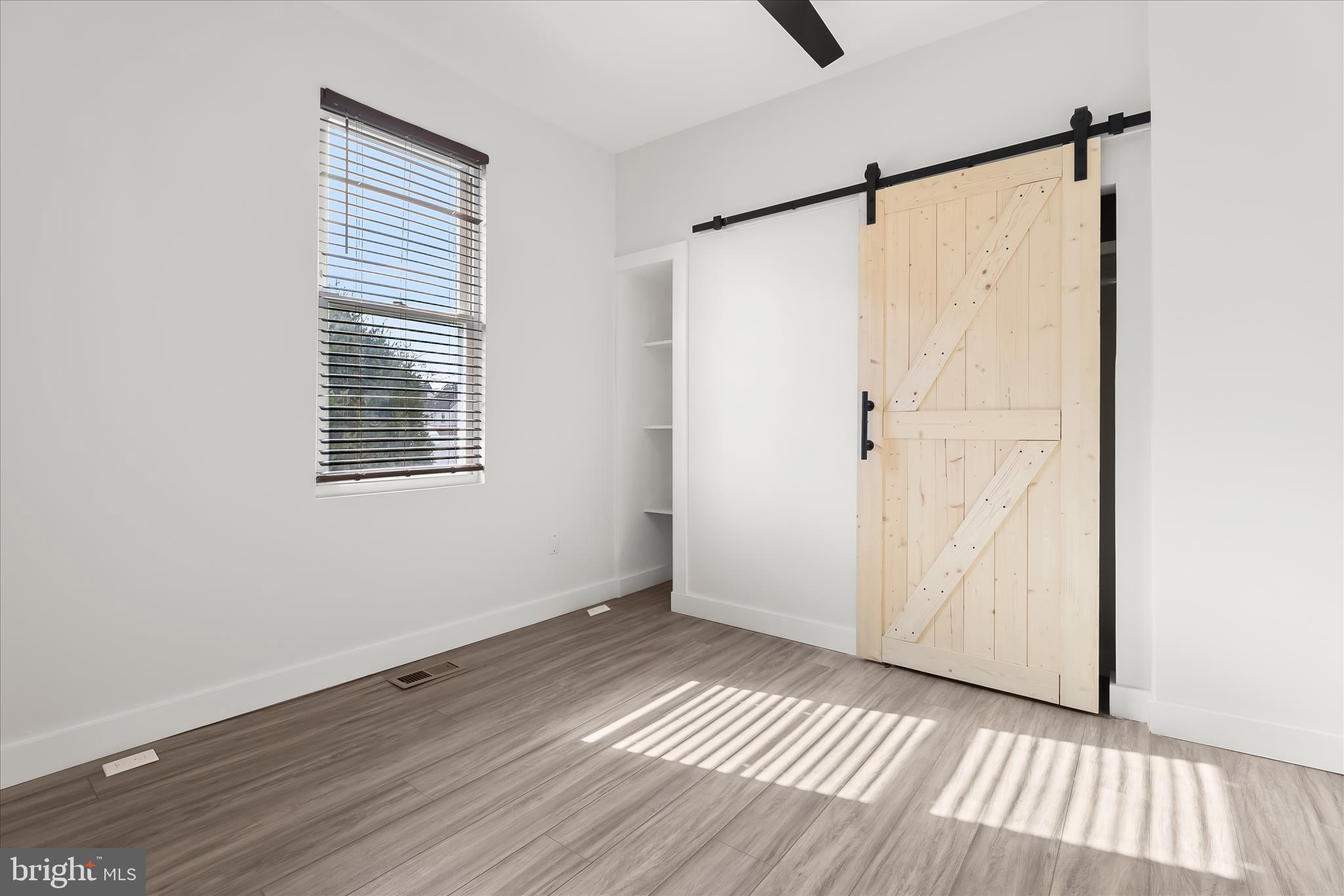 5822 Ethelbert Avenue Baltimore, MD 21215 - Photo 20 of 37 a view of an empty room with wooden floor and a window