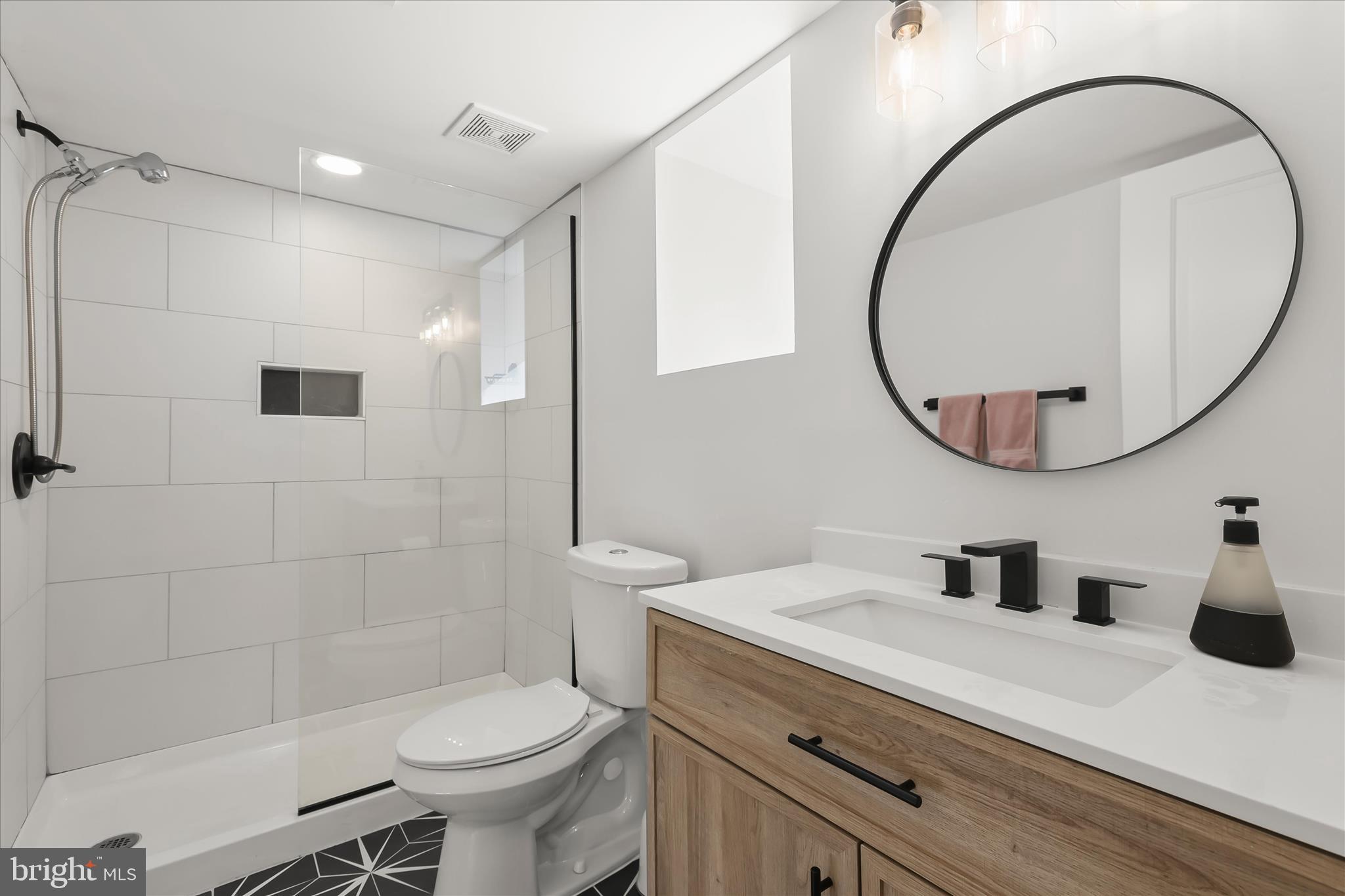 5822 Ethelbert Avenue Baltimore, MD 21215 - Photo 29 of 37 a bathroom with a sink a toilet and a mirror