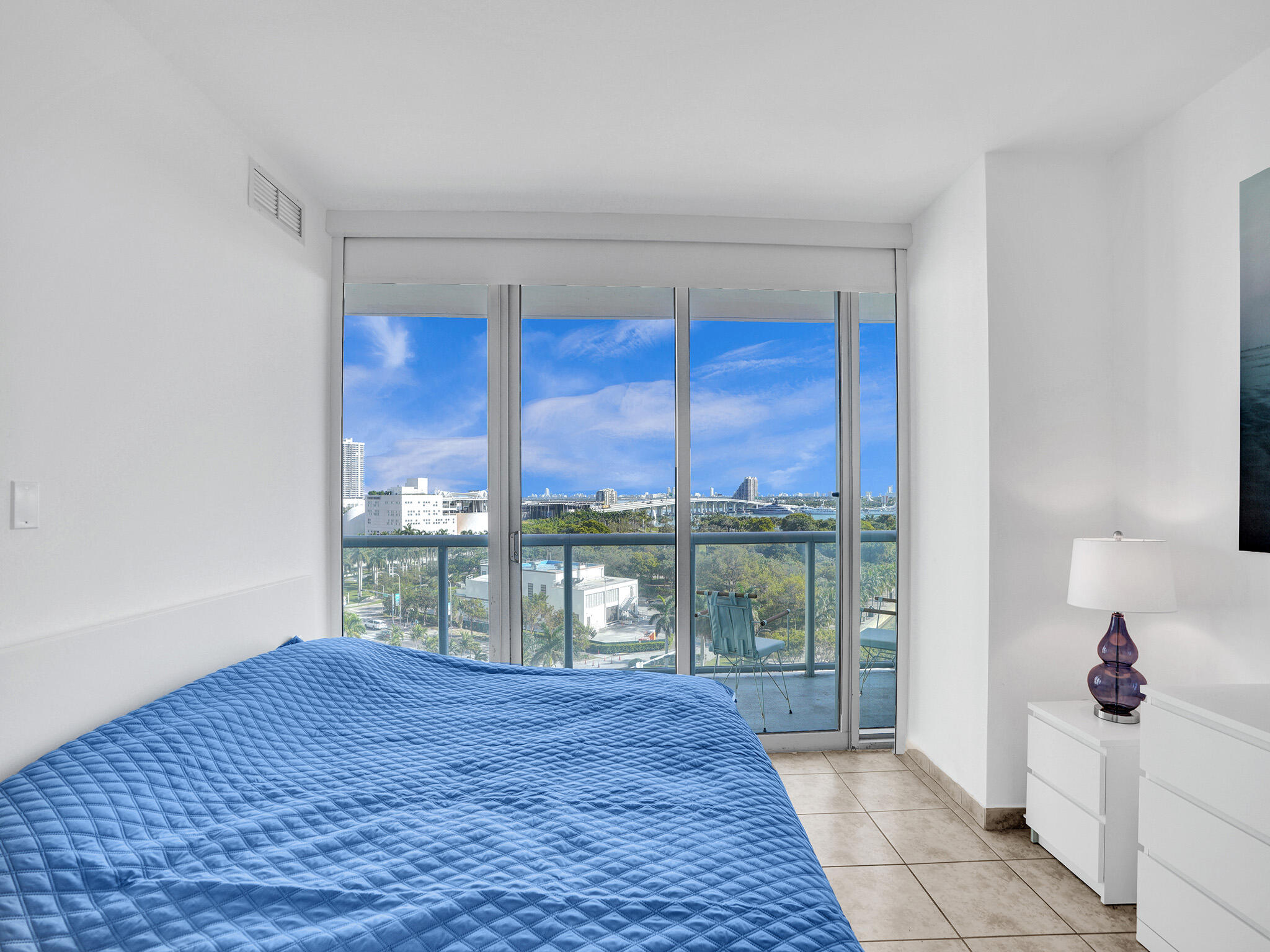 888 Biscayne Boulevard, Unit 811 Miami, FL 33132 - Photo 16 of 48 a bedroom with a large window and a bed