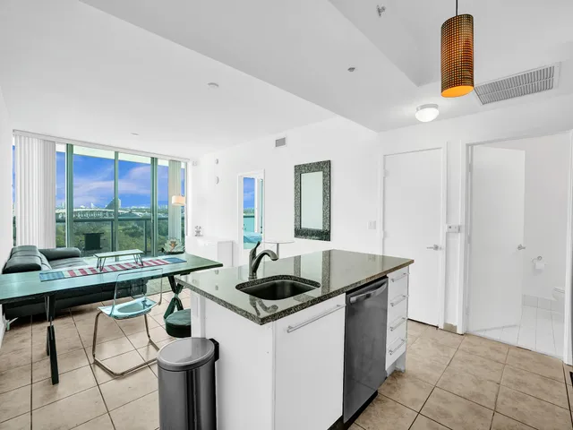 a kitchen with a sink a stove and chairs