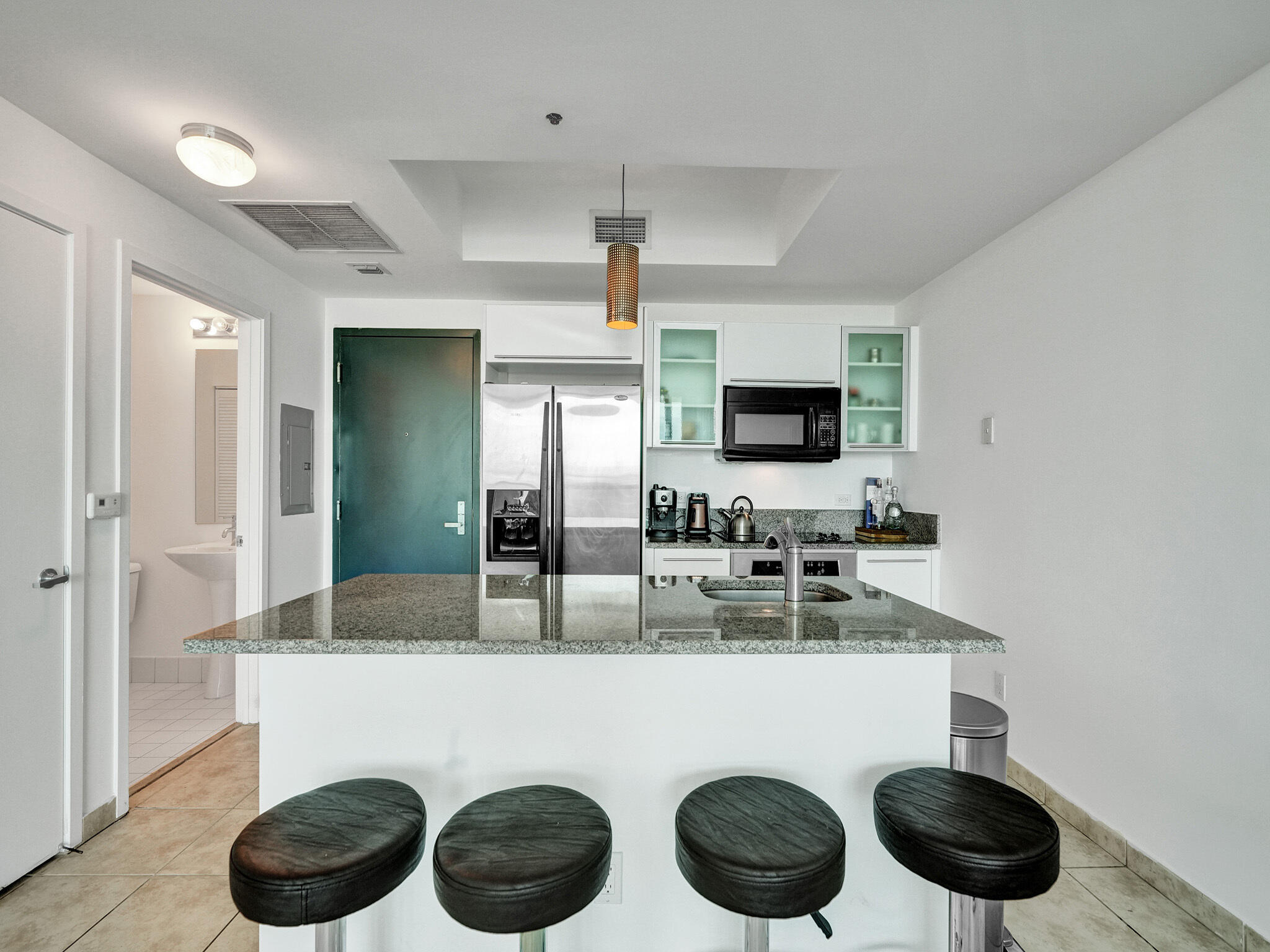 888 Biscayne Boulevard, Unit 811 Miami, FL 33132 - Photo 7 of 48 a kitchen with a sink a stove and chairs