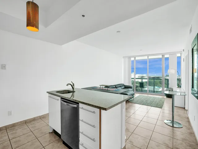 a living room with furniture and a dining table with kitchen view