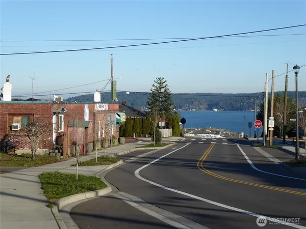 a view of a city street with a car parked on the road