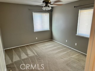 1320 Cadwell Court Riverside, CA 92506 - Photo 22 of 44 an empty room with a chandelier fan and windows