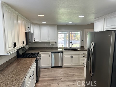 1320 Cadwell Court Riverside, CA 92506 - Photo 10 of 44 a kitchen with a refrigerator sink and cabinets