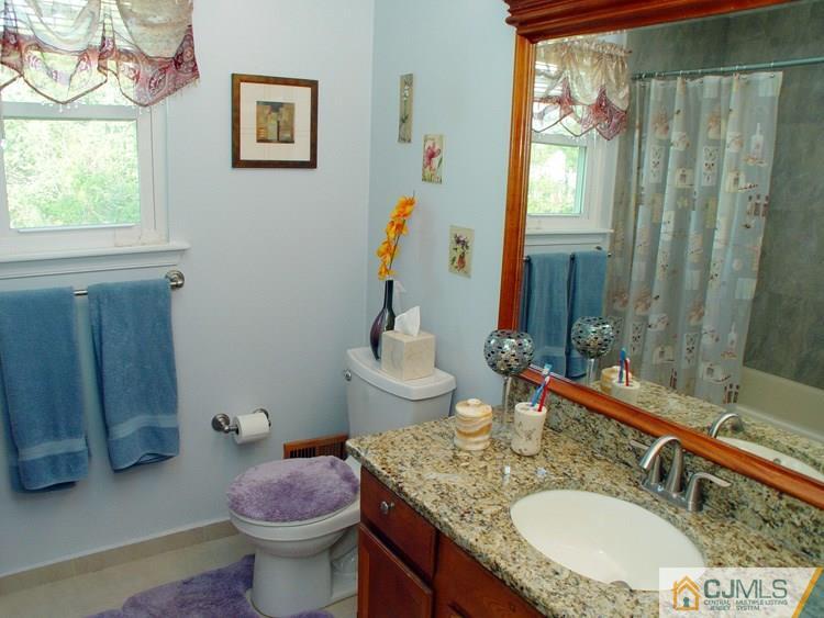 21 Smithwold Road Somerset, NJ 08873 - Photo 14 of 20 a bathroom with a granite countertop sink a toilet and a mirror