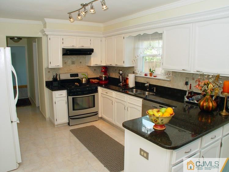 21 Smithwold Road Somerset, NJ 08873 - Photo 7 of 20 a kitchen with stainless steel appliances kitchen island granite countertop a sink stove and refrigerator