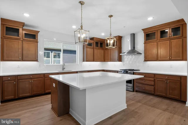 a kitchen with stainless steel appliances granite countertop a stove a sink dishwasher a refrigerator and a oven with wooden floor