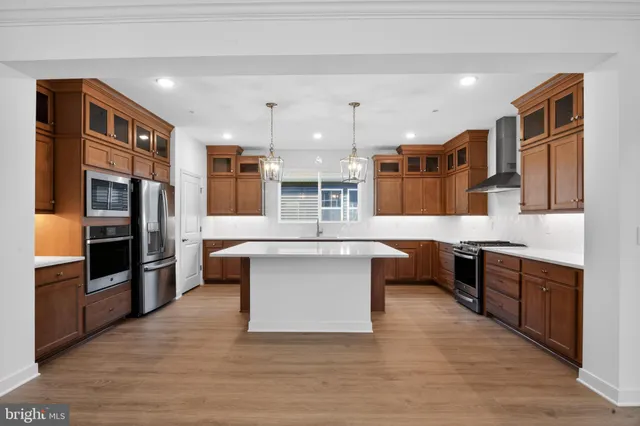 a large kitchen with stainless steel appliances wooden floors and wooden cabinets