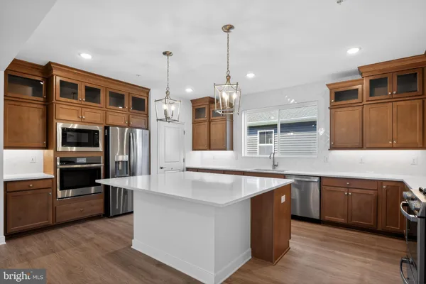 a large kitchen with stainless steel appliances granite countertop a lot of counter space and wooden floor