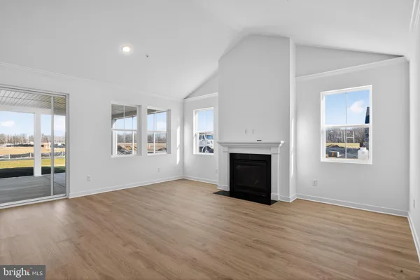 an empty room with windows and fireplace