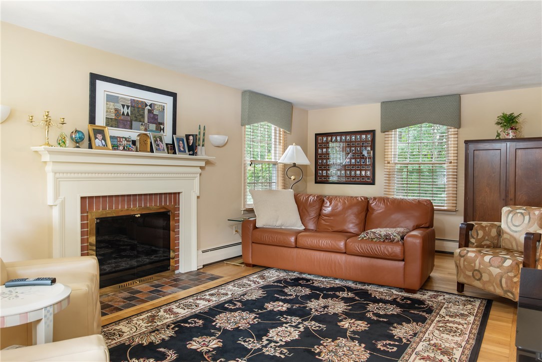 70 Timberline Road Warwick, RI 02886 - Photo 3 of 32 Front to back large living room with wood burning fireplace, hardwood floors, alabaster marble sconces and lovely window treatments