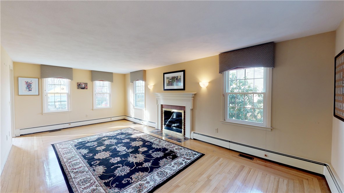 70 Timberline Road Warwick, RI 02886 - Photo 4 of 32 Front to back large living room with wood burning fireplace, hardwood floors, alabaster marble sconces and lovely window treatments