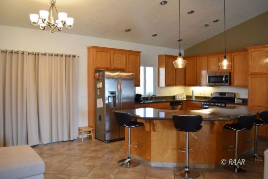 412 Abigail Street Ridgecrest, CA 93555 - Photo 6 of 14 a kitchen with stainless steel appliances granite countertop a stove a refrigerator a oven a sink with a dining table and chair