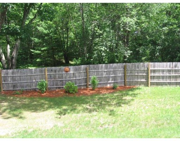 749 Lowell Road, Unit B Groton, MA 01450 - Photo 4 of 16 a view of a yard with a wooden fence