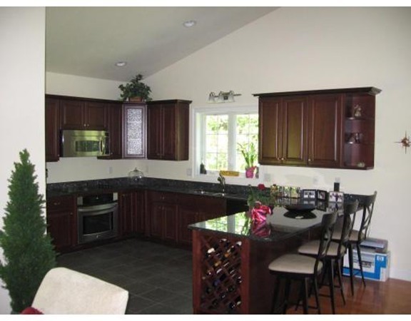 749 Lowell Road, Unit B Groton, MA 01450 - Photo 6 of 16 a kitchen with a sink stove and cabinets