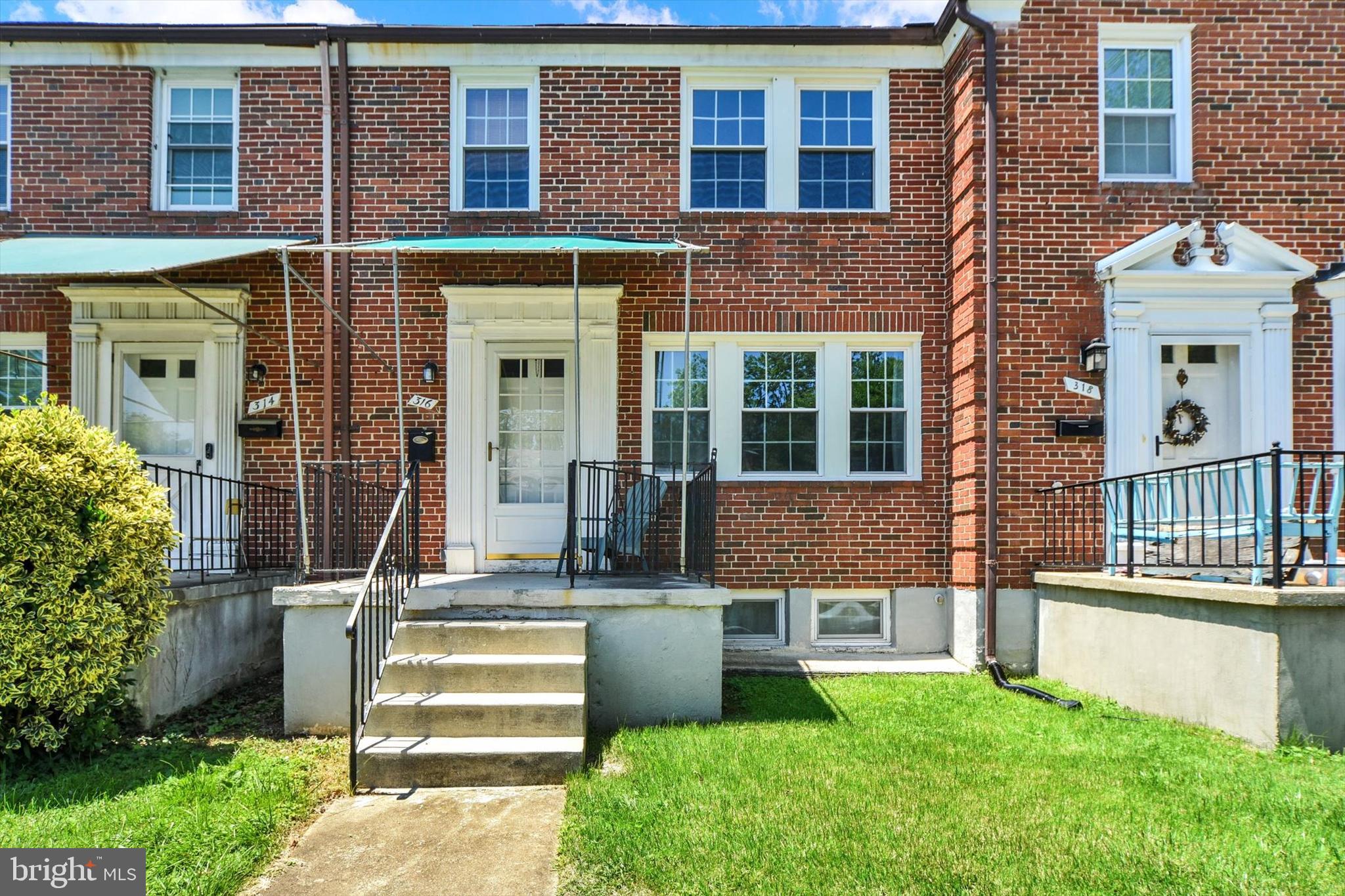 316 Lambeth Road Baltimore, MD 21228 - Photo 1 of 28 front view of a brick house with a yard