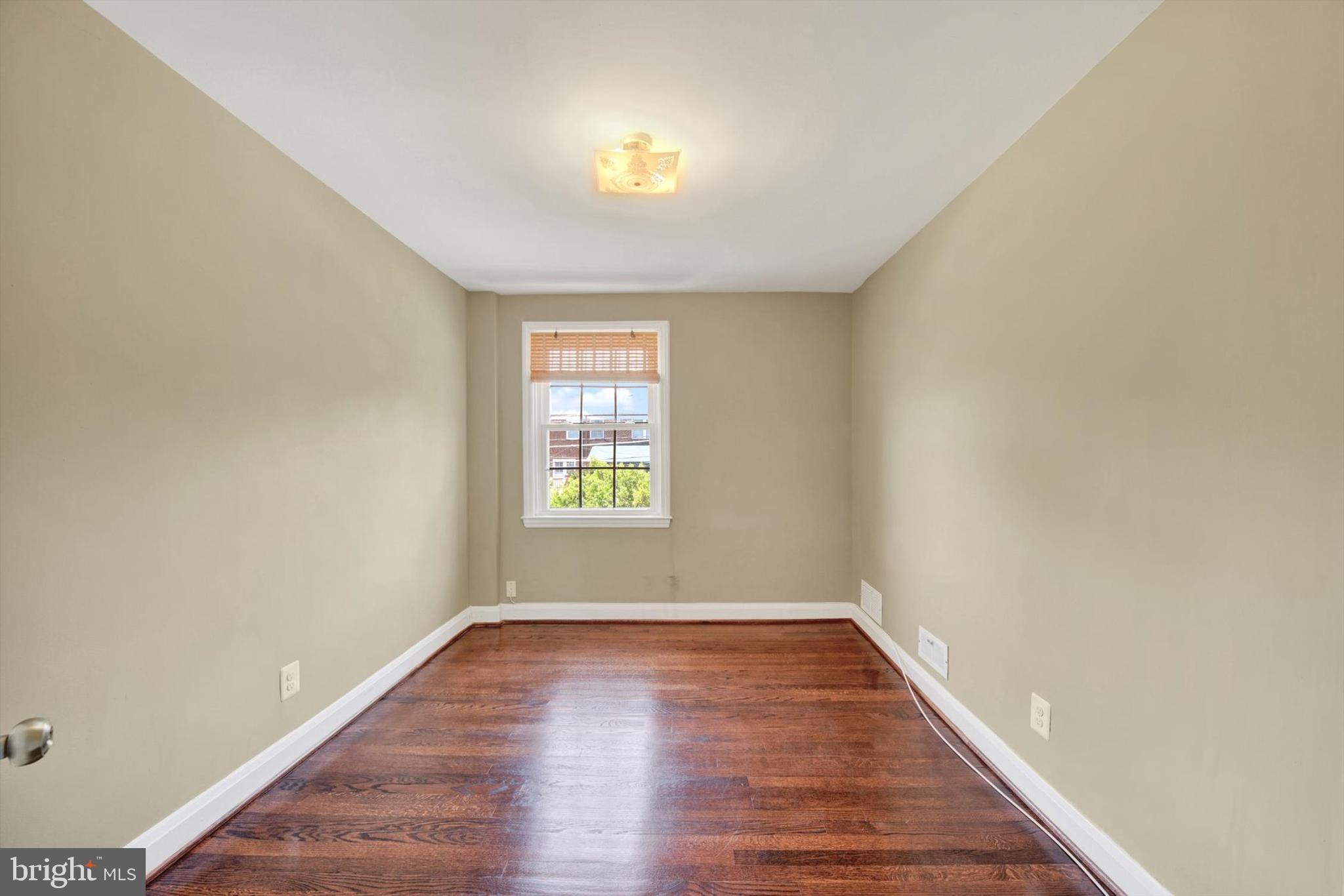 316 Lambeth Road Baltimore, MD 21228 - Photo 13 of 28 an empty room with wooden floor and windows