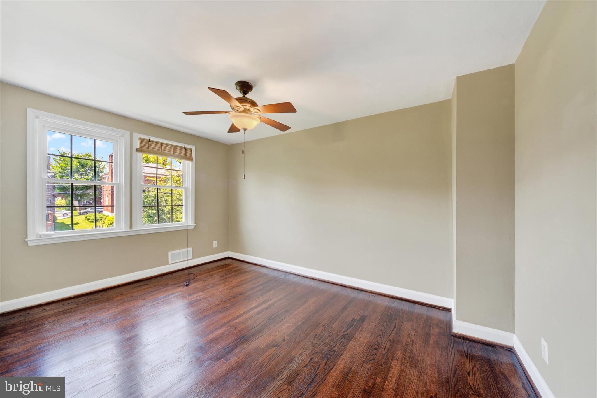 316 Lambeth Road Baltimore, MD 21228 - Photo 17 of 28 an empty room with wooden floor and windows