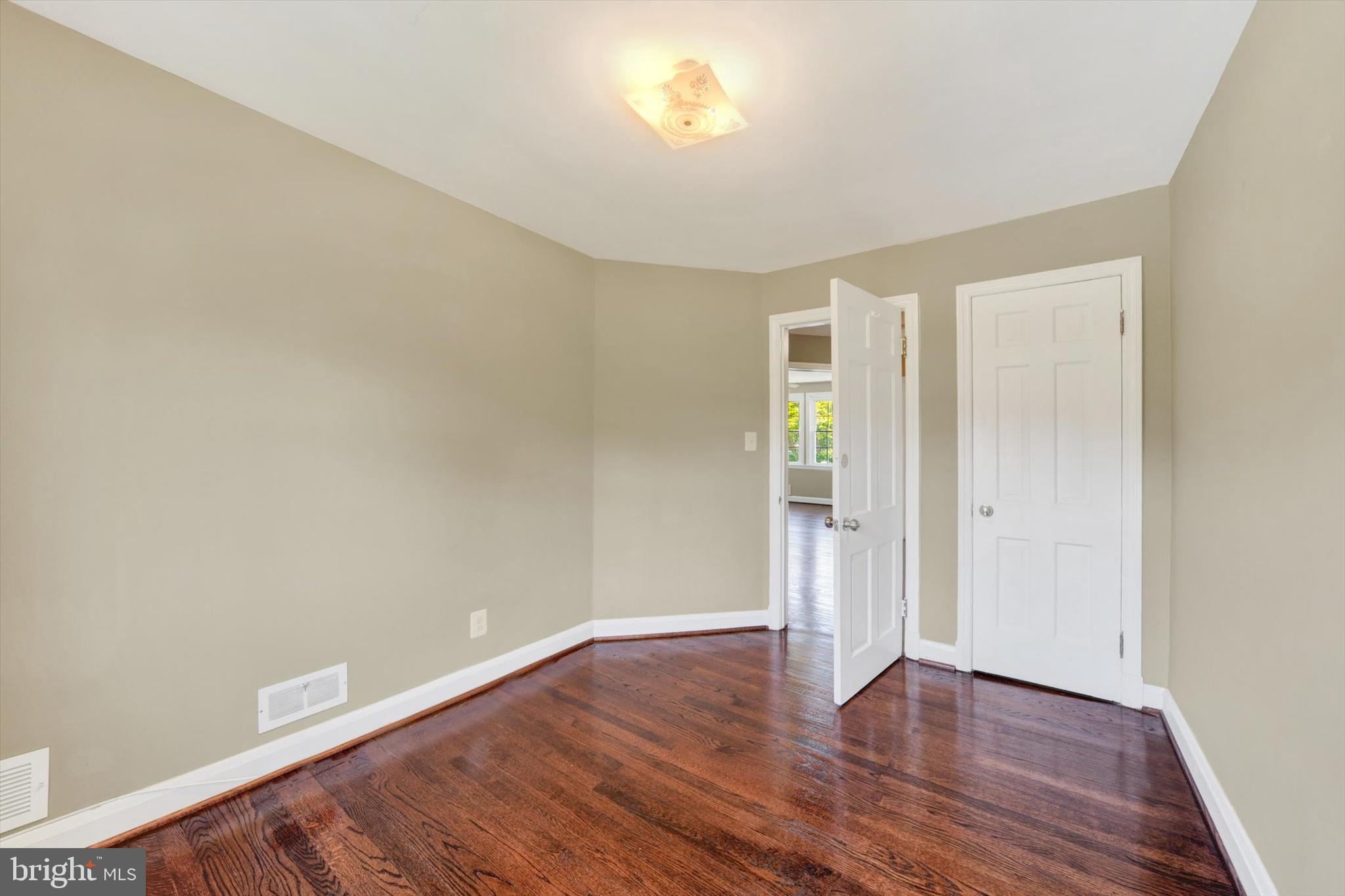 316 Lambeth Road Baltimore, MD 21228 - Photo 18 of 28 an empty room with wooden floor and windows